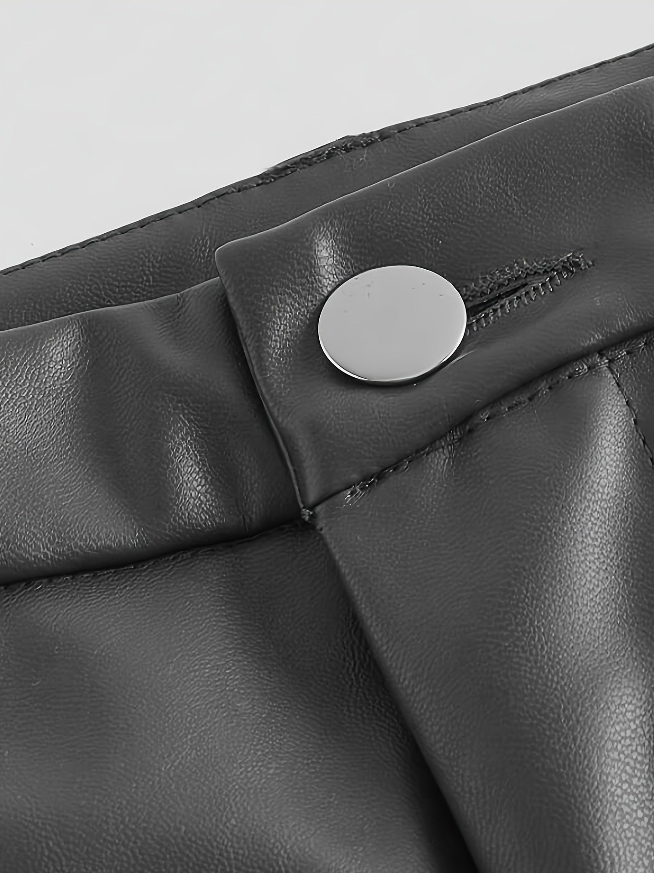 Calça em couro sintético com bolsos e fechamento em botão